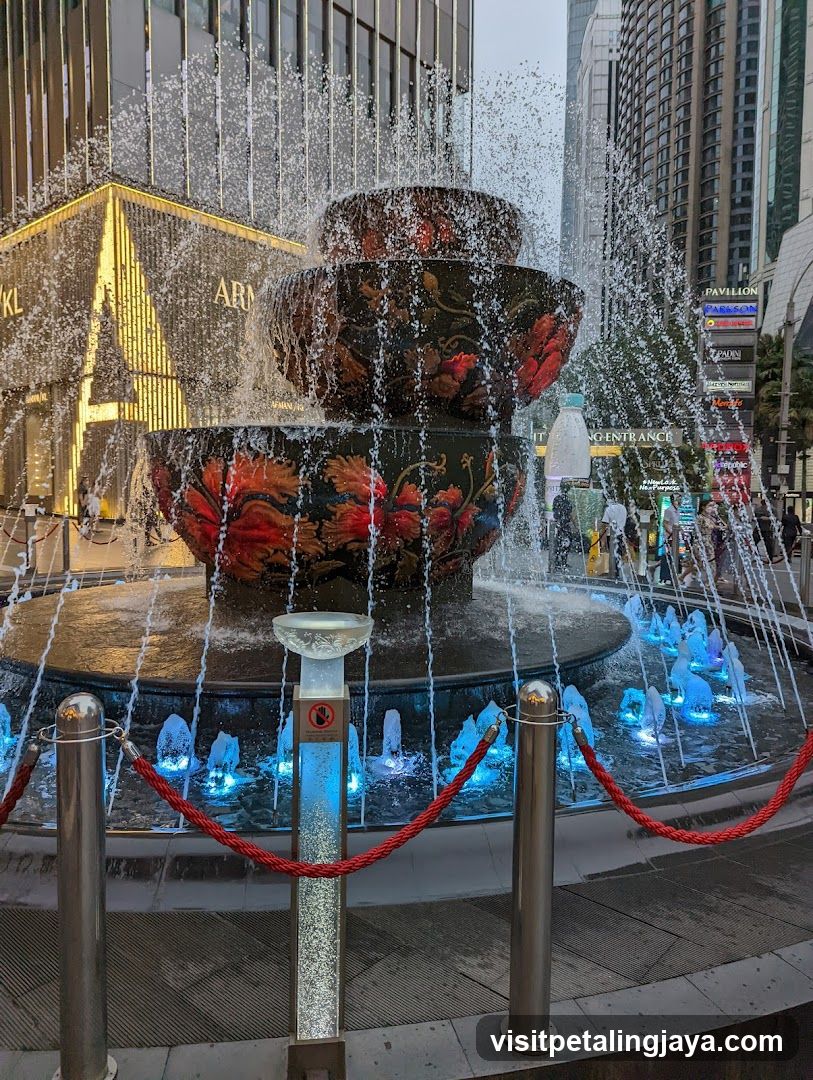 Fountain with illuminated water jets and surrounding urban buildings