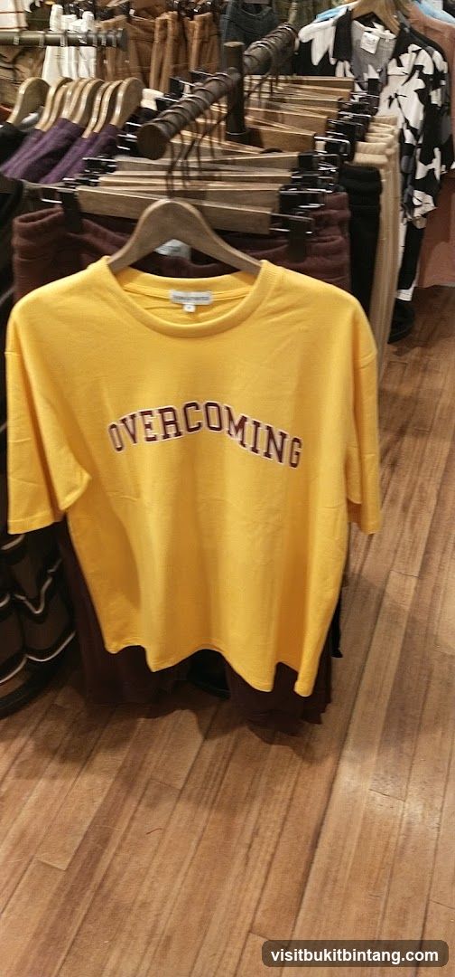 Yellow T-shirt with "OVERCOMING" text