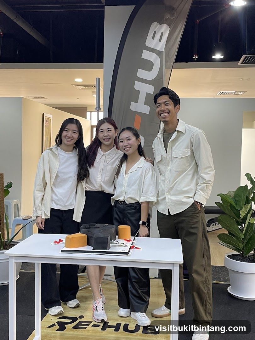 Four people posing behind a table with a cake
