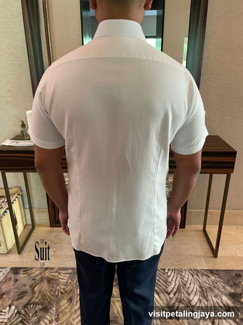 Man wearing white shirt and dark pants indoors