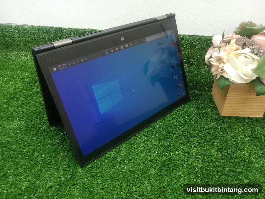 Laptop on artificial grass with flowers