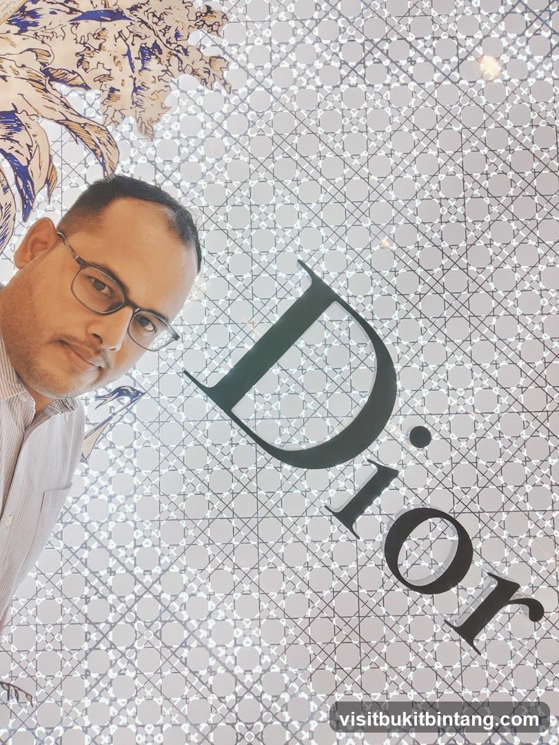 Man Posing in Front of Dior Logo