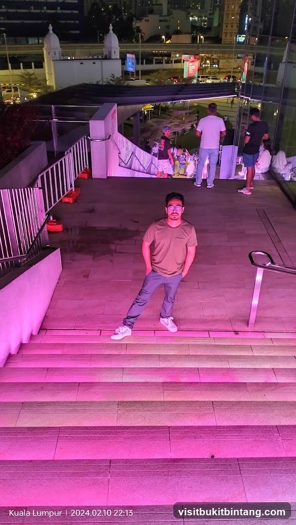 Man posing on illuminated stairs at night