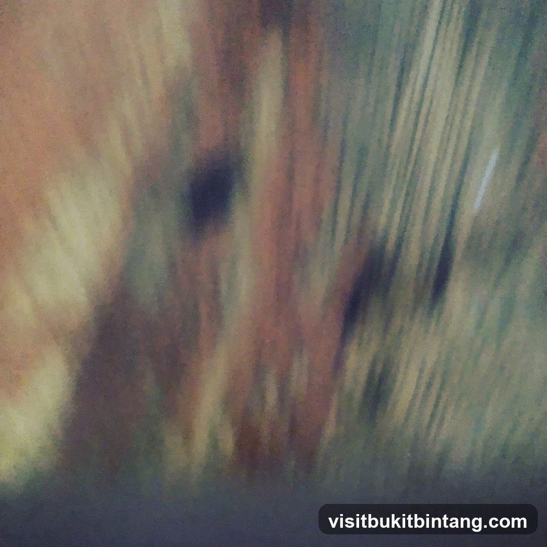 The image is an abstract, blurry depiction of vertical lines in shades of brown, green, and yellow. The lines are blurred and appear to be in motion, creating a sense of movement or a streaky effect. There are darker patches within the lighter areas, adding some contrast. The overall impression is of a textured, abstract pattern.