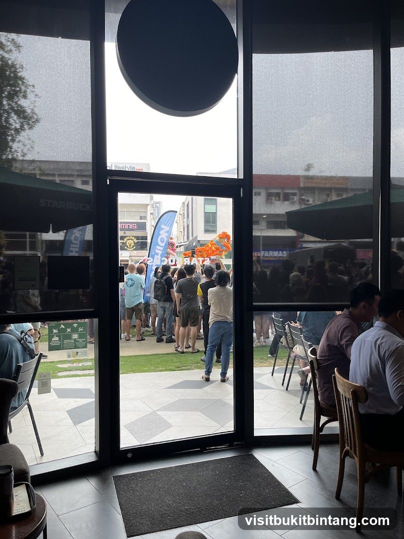 People watching a dragon dance performance outside a Starbucks