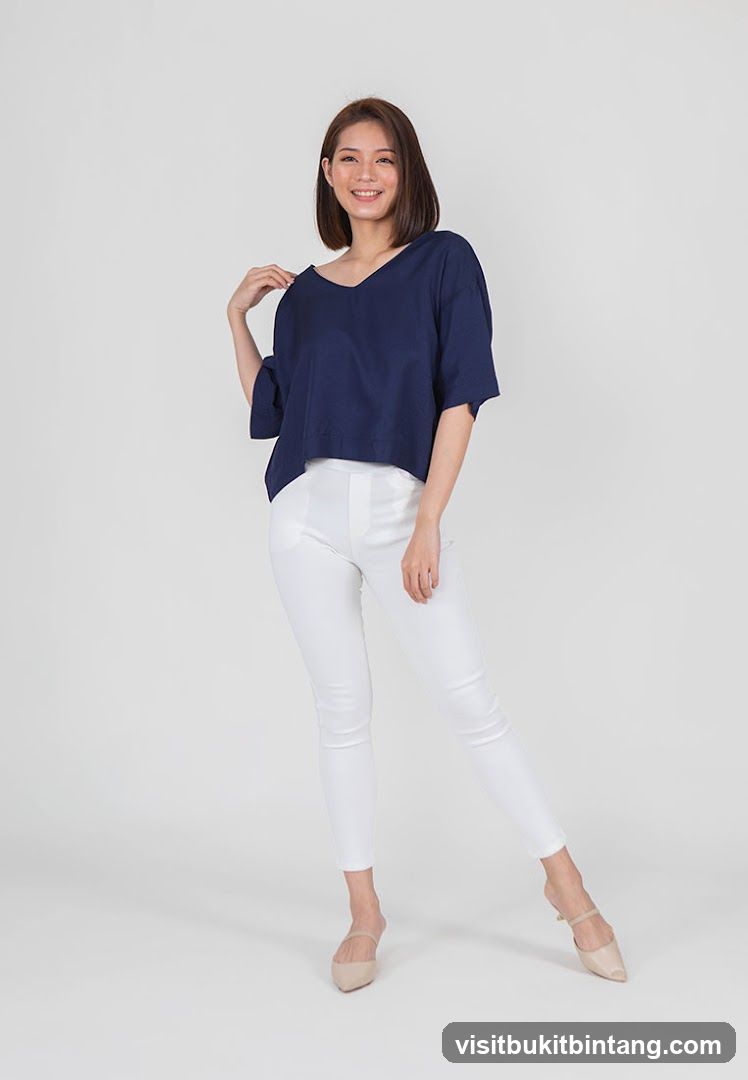 Woman in navy top and white pants
