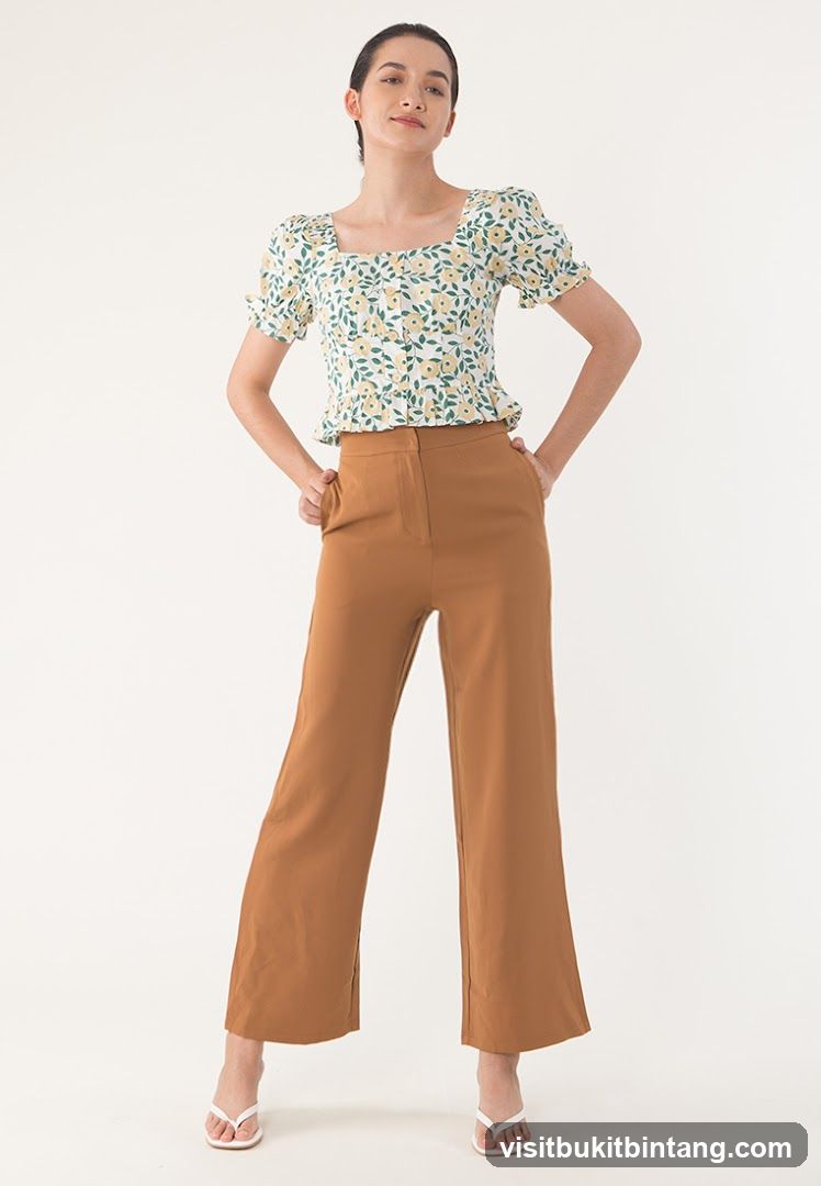 Woman in floral top and brown pants
