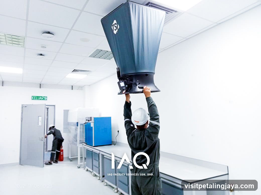 Worker installing industrial equipment in cleanroom facility