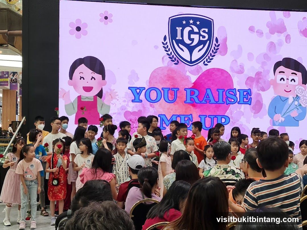 Children and Adults on Stage with a Screen Display