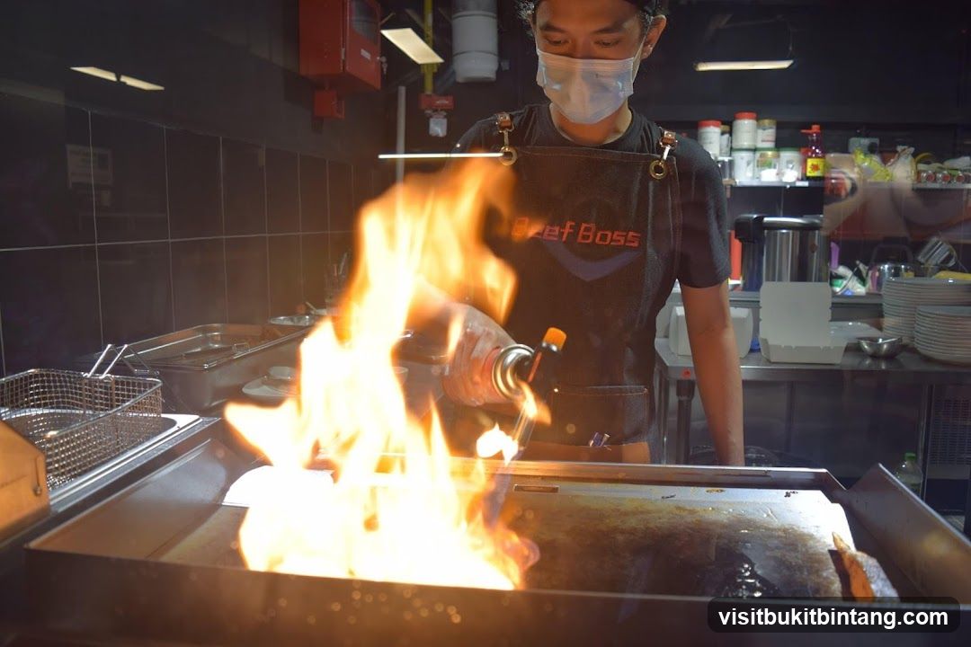 Chef using a torch on a grill