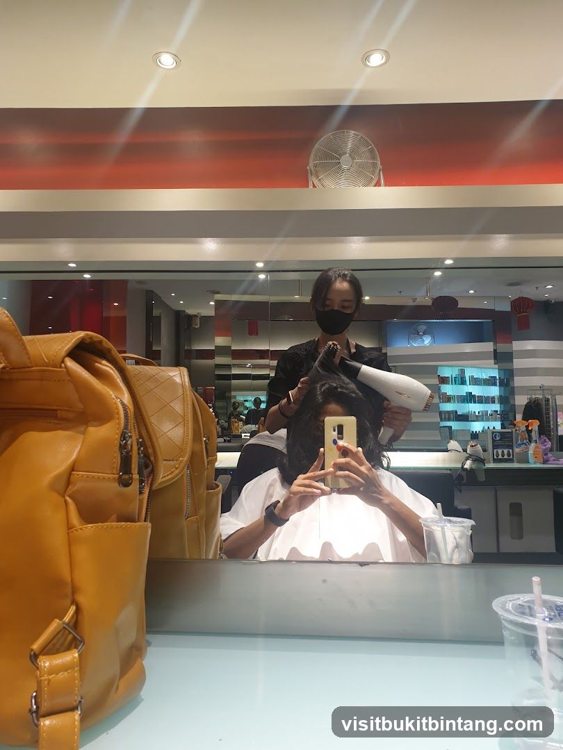 Hairdresser drying client's hair