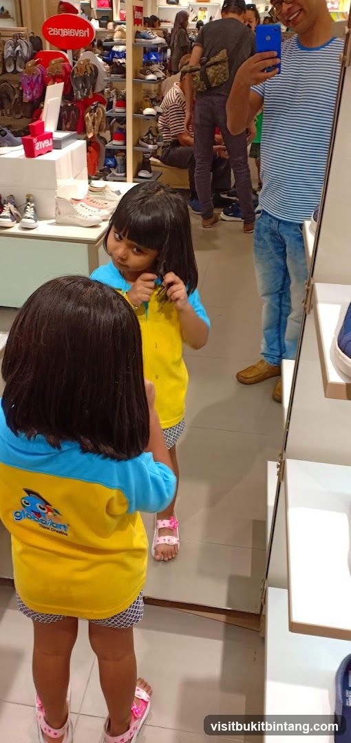 Girl looking in mirror at shoe store