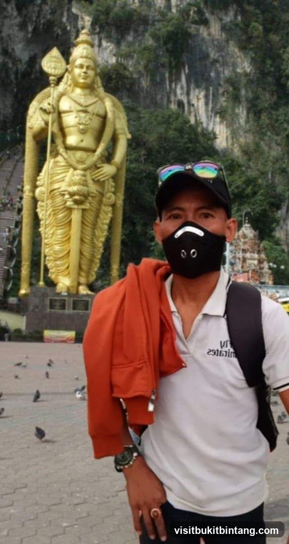 Man Posing in Front of a Large Golden Statue