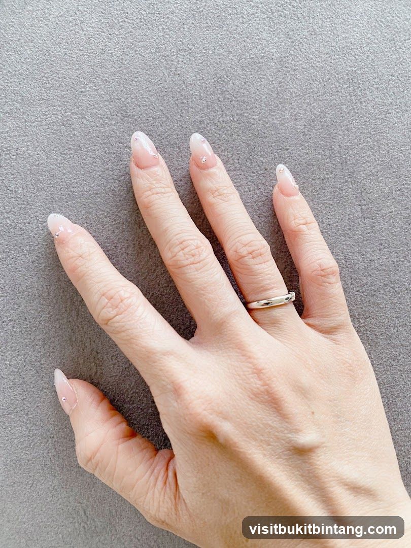 Hand with French tip nails and ring
