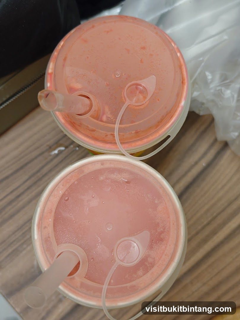 Two pink drinks with straws