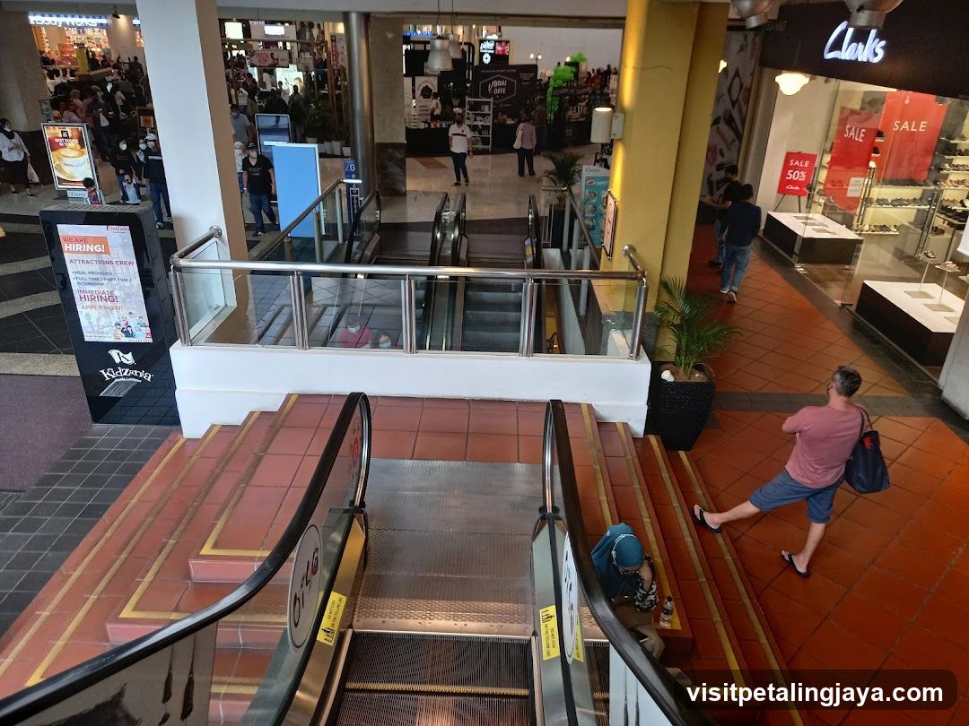 Shopping Mall Interior with Escalators and Storefronts