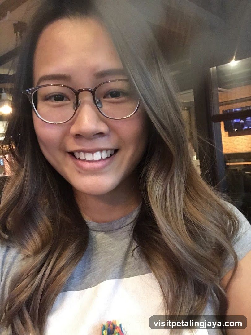 Selfie of a woman with glasses and wavy hair