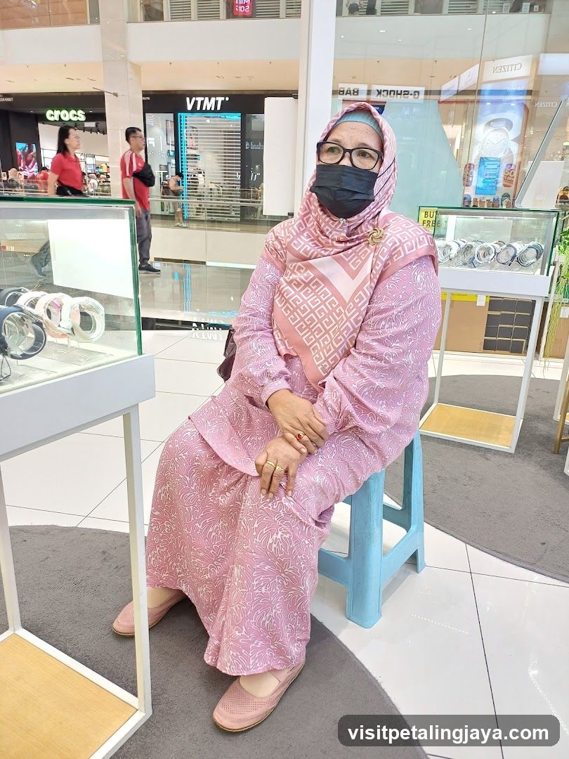 Woman in pink hijab sitting in mall jewelry store