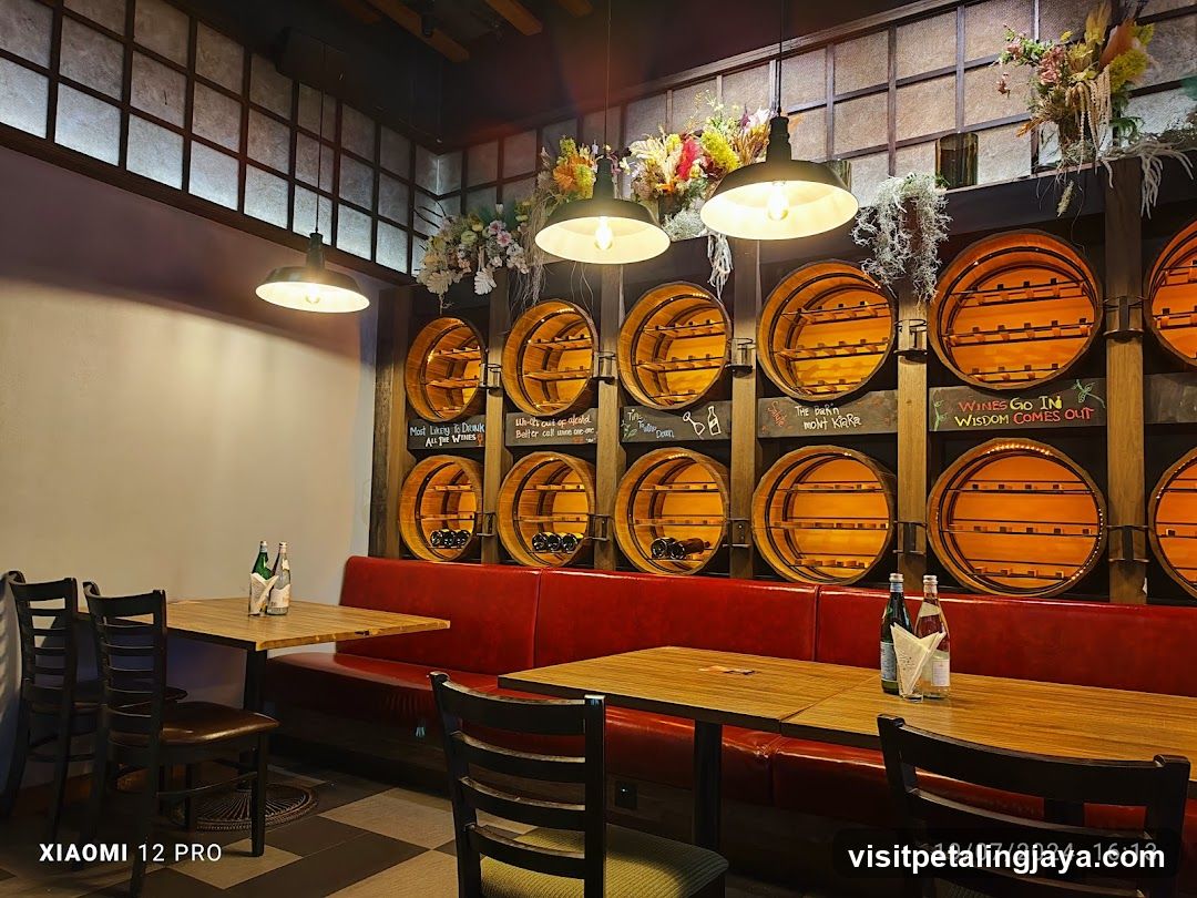Interior of a cozy restaurant with wooden barrels and red booth seating