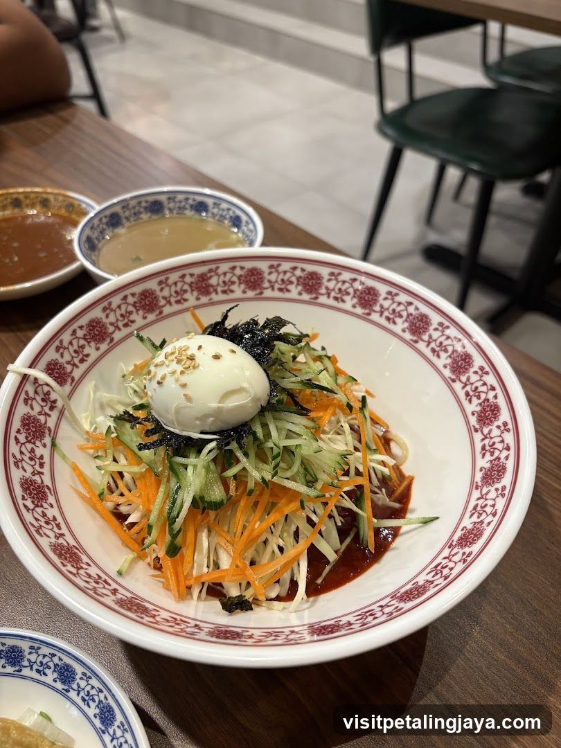 Bowl of Korean-style cold noodle salad with egg and vegetables
