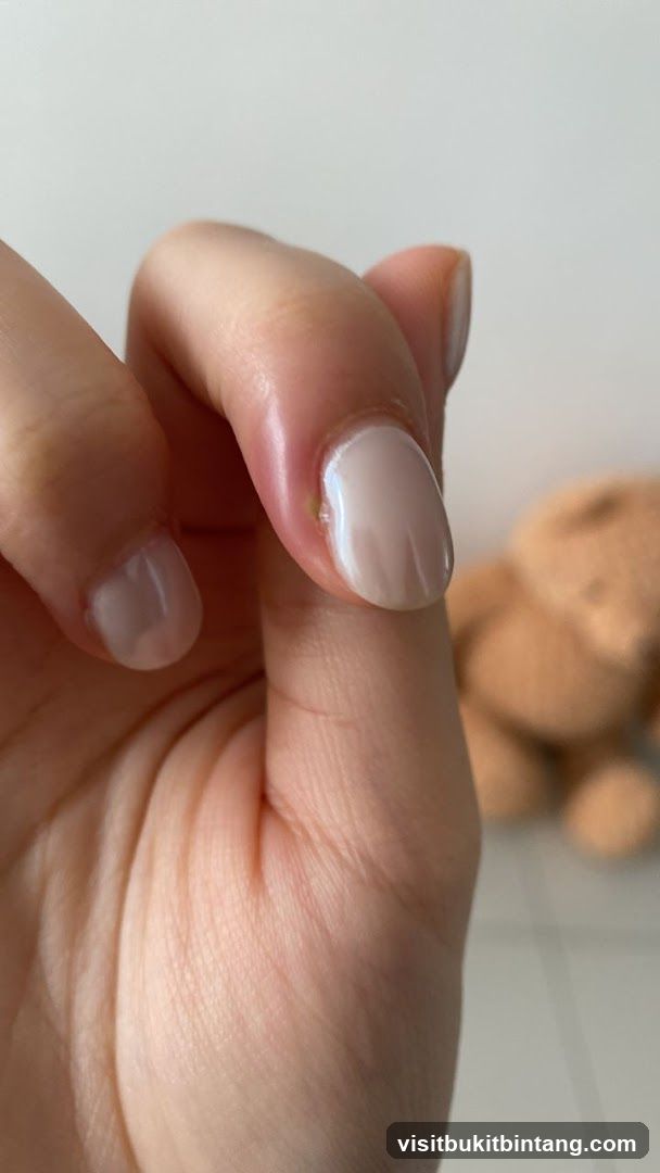 Close-up of a hand with light-colored nail polish