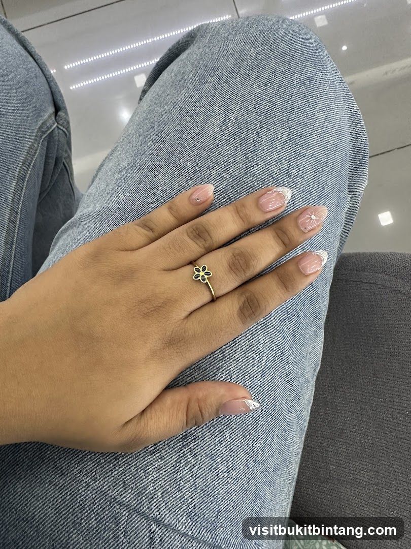 Woman's hand with flower ring and French manicure