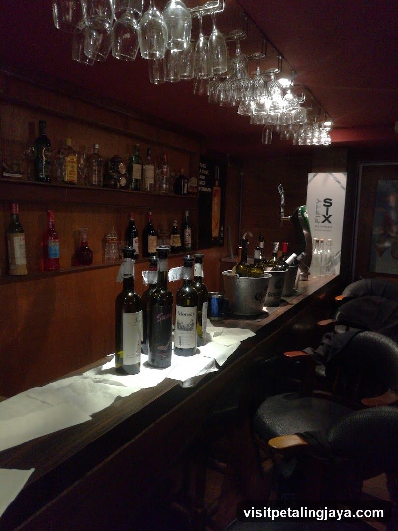 Bar Interior with Wine Bottles and Hanging Glasses