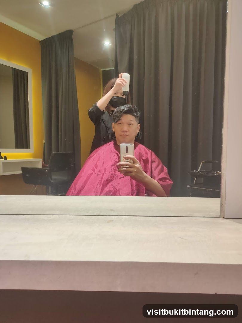 Hairdresser spraying client's hair