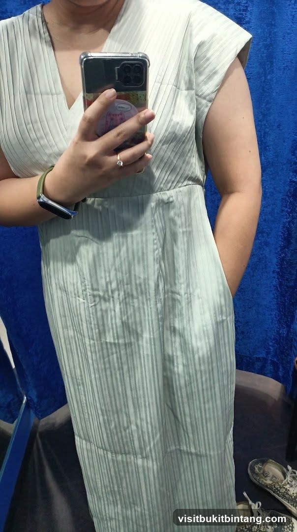 Woman in a pleated dress taking a selfie