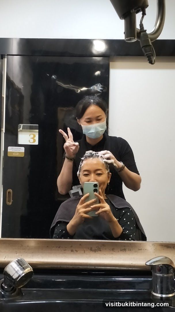 Hairdresser washing client's hair