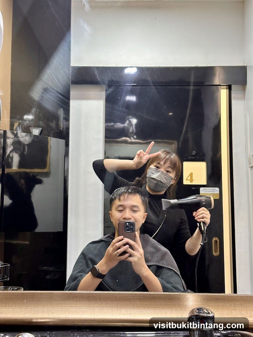 Hairdresser drying client's hair
