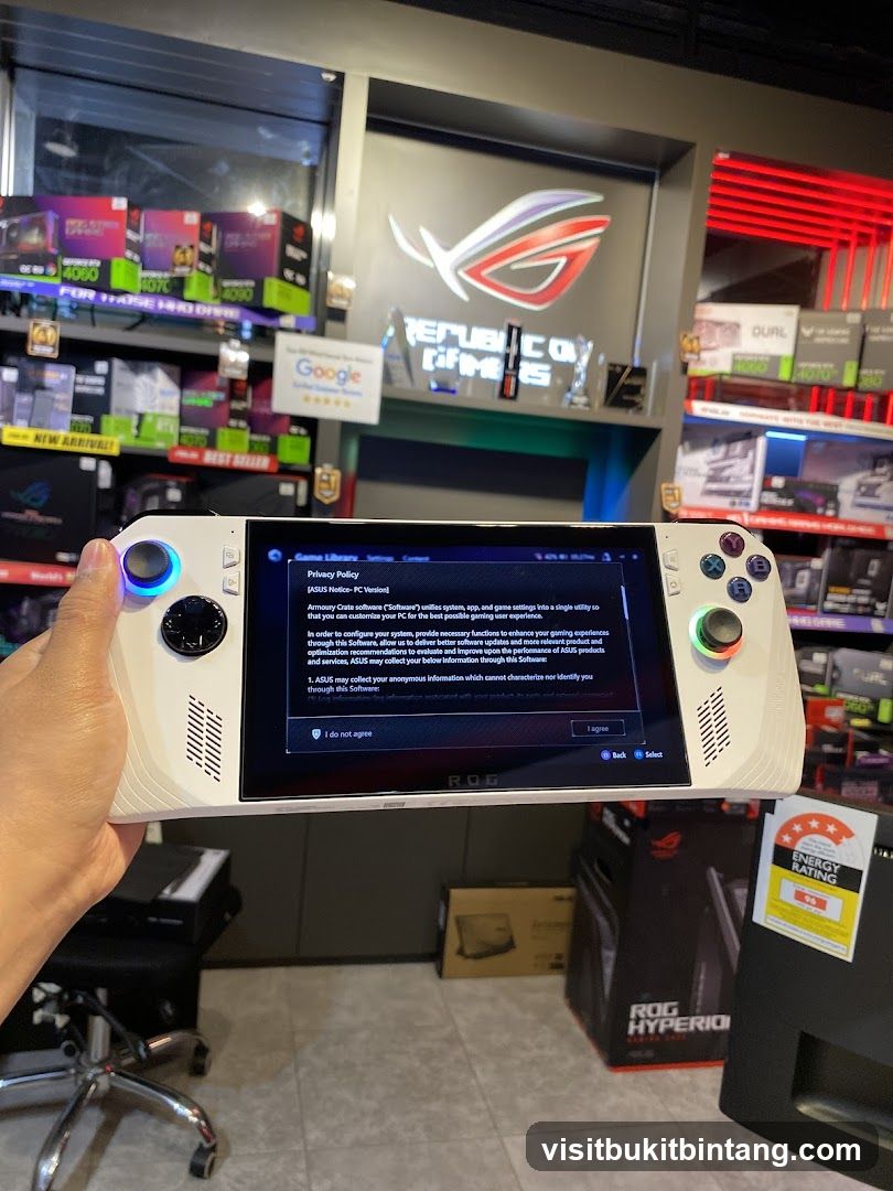 Hand holding a white gaming handheld device with a privacy policy on screen