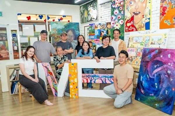 Artists and students with large ME letters and paintings for the OUR WORLD 2026 collabs