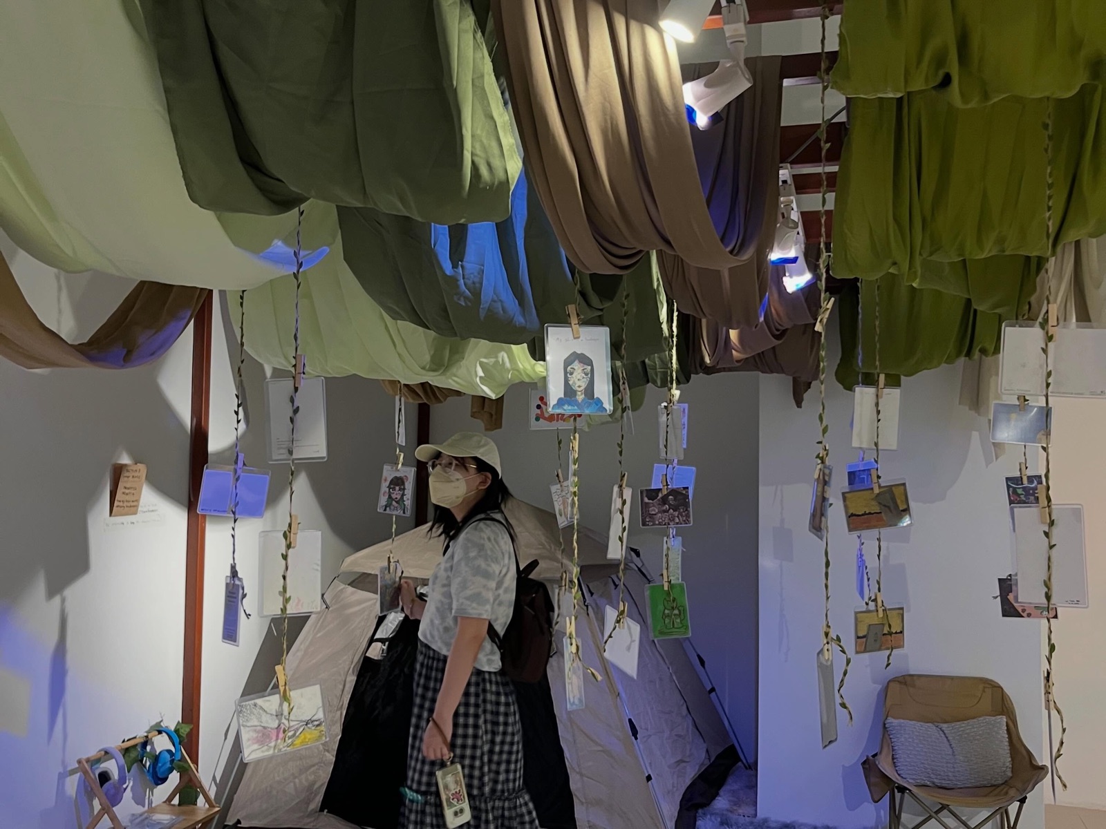 Visitor under the fabric canopy and hanging A6 cards at The Ways We Human, GMBB Level 3
